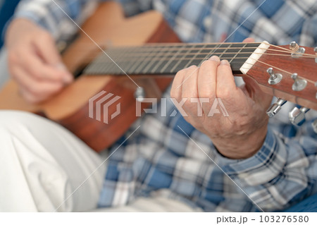 ギターを弾くシニア男性　手元 103276580