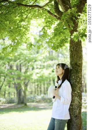 森の中でリラックスしながら森林浴を楽しむ30代日本人女性の初夏のイメージ 103277129