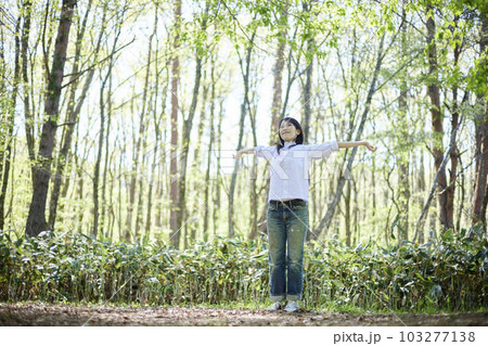 初夏の森でリラックスしながら伸びをする30代日本人女性 103277138
