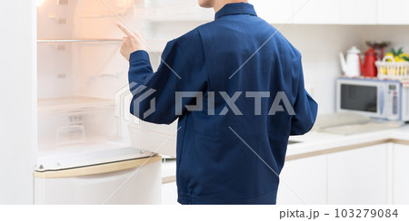 冷蔵庫の扉を開けて確認する修理業者 103279084