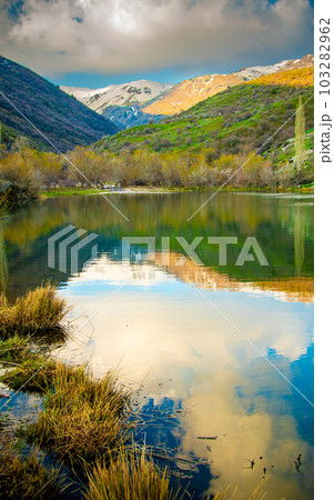 Beautiful alpine lake with reflections of beautiful clouds in the water. Kazgurt district Aksujabagly nature reserve lake syrgan in Kazakhstan Beautiful alpine lake with reflections of beautiful clouds in the water. Kazgurt district Aksujabagly nature reserve lake syrgan in Kazakhstan 103282962