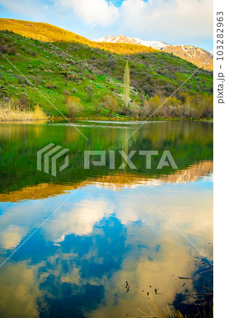 Beautiful alpine lake with reflections of beautiful clouds in the water. Kazgurt district Aksujabagly nature reserve lake syrgan in Kazakhstan Beautiful alpine lake with reflections of beautiful clouds in the water. Kazgurt district Aksujabagly nature reserve lake syrgan in Kazakhstan 103282963