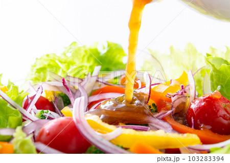 野菜サラダに和風ドレッシングをかける 103283394