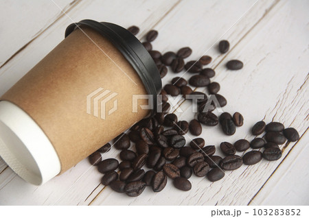 Takeaway coffee cup fall on coffee beans with customizable space for text or ideas. Copy space and coffee concept. 103283852
