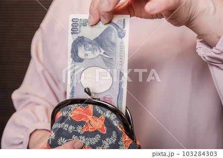 【がま口から1000円札を出す主婦】 【がま口から1000円札を出す主婦】 103284303