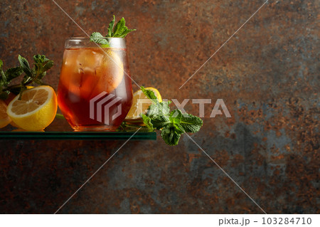 Iced tea with lemon and mint on a background of rustic wall. 103284710