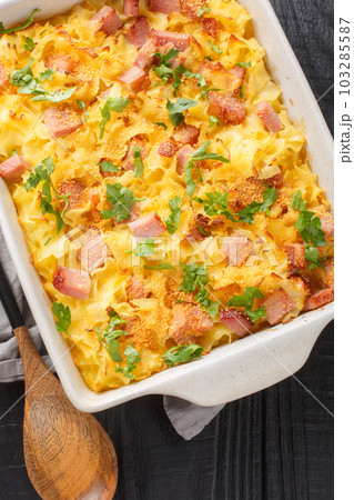 Uberbackene Schinkenfleckerl Gratinated Ham Pasta closeup on the baking dish. Vertical top view 103285587