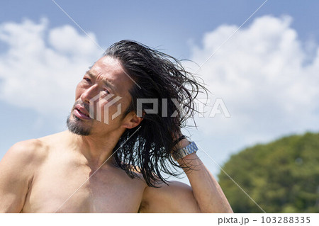 青空の屋外で濡れた髪の毛を乾かすミドルシニア男性 103288335