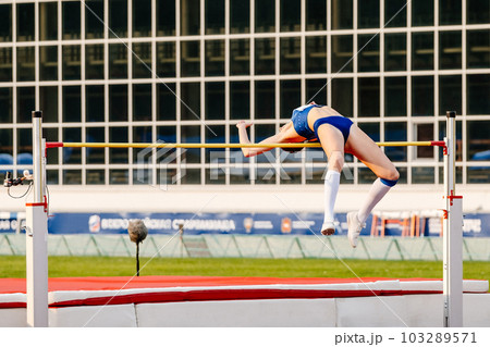 woman athlete going over bar high jump in summer athletics championships, fosbury flop technique woman athlete going over bar high jump in summer athletics championships, fosbury flop technique 103289571
