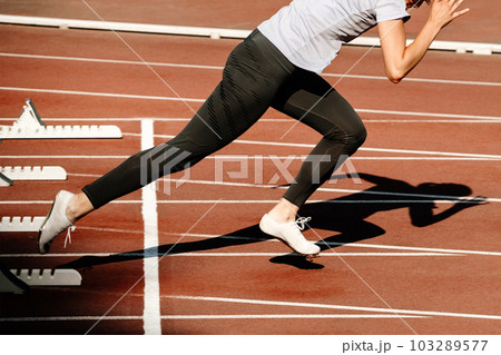 woman sprinter start running from starting blocks 100 metres race in summer athletics championships 103289577