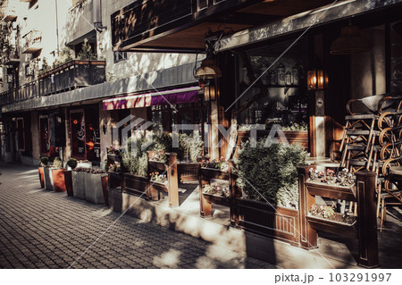 Street view with beautiful buildings and cafe terrace during the morning light concept photo. Street view with beautiful buildings and cafe terrace during the morning light concept photo. 103291997
