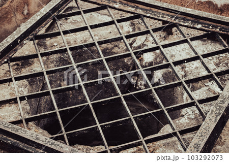Close up old water well with iron grille close up photo. Street scene. High quality picture for wallpaper, travel blog, magazine, article Close up old water well with iron grille close up photo. Street scene. High quality picture for wallpaper, travel blog, magazine, article 103292073