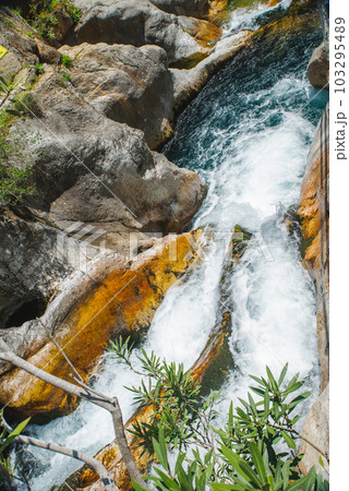 Female slackliner walking a highline over a waterfall 103295489