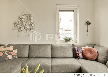 a living room with a couch and some decorative objects on the wall in front of the couch is made out of grey fabric 103295504