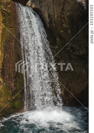 Female slackliner walking a highline over a waterfall 103295505