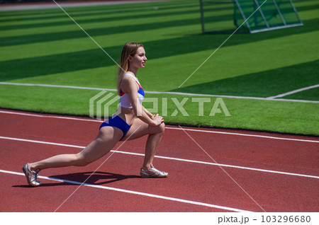 Young caucasian woman is engaged in jogging at the stadium outdoors. 103296680
