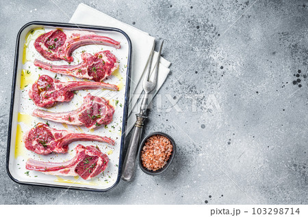 Ready for cooking raw lamb chop steaks with spices and herbs. Gray background. Top view. Copy space 103298714