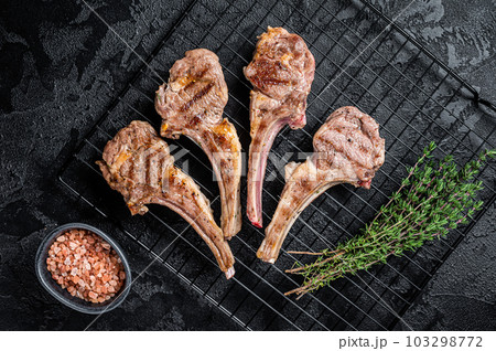 Barbecue Grilled lamb meat chops, mutton cutlets. Black background. Top view Barbecue Grilled lamb meat chops, mutton cutlets. Black background. Top view 103298772