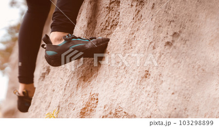 Woman is climbing, training on the mountains, feets closeup. Woman is climbing, training on the mountains, feets closeup. 103298899