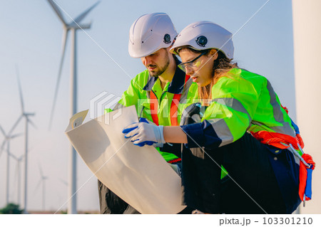 Professional engineer technician working outdoor at wind turbine field 103301210