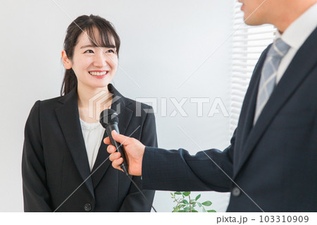 インタビュー・取材を受けるスーツを着た笑顔のアジア人女性 インタビュー・取材を受けるスーツを着た笑顔のアジア人女性 103310909