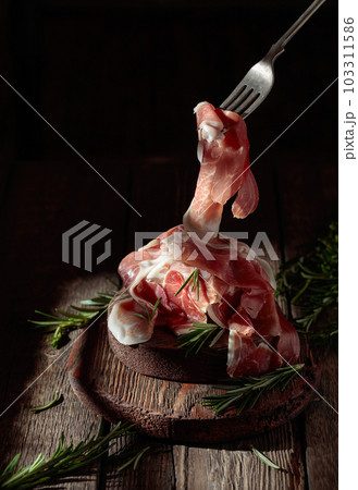 Italian prosciutto or Spanish jamon with rosemary. Italian prosciutto or Spanish jamon with rosemary. 103311586