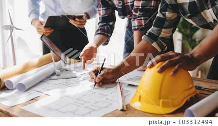 Engineer teams meeting working together wear worker helmets hardhat on construction site in modern city. industry professional team in office. Engineer teams meeting working together wear worker helmets hardhat on construction site in modern city. industry professional team in office. 103312494