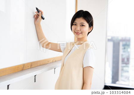 会議室でホワイトボードに書き込む女性04 103314084