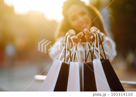Shopping bags in the woman hands. Sale, shopping, tourism and happy people concept. 103314110