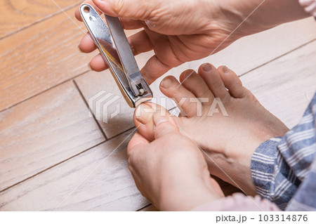 【足の爪を切るミドル女性　フローリング】 103314876