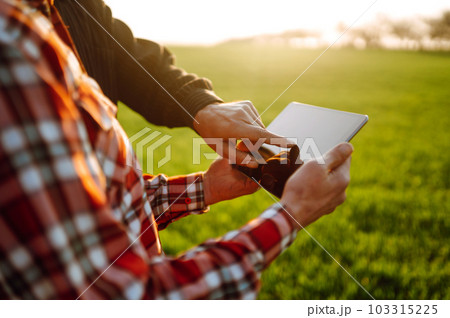 Farmers with tablet in the field. Farmers using touch pad for check wheat quality in the field. Farmers with tablet in the field. Farmers using touch pad for check wheat quality in the field. 103315225