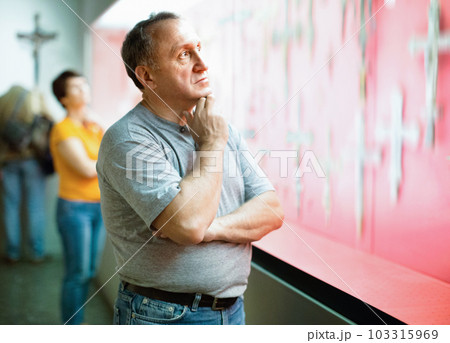 Portrait of thoughtful elderly man examining exposition in museum hall of applied arts 103315969