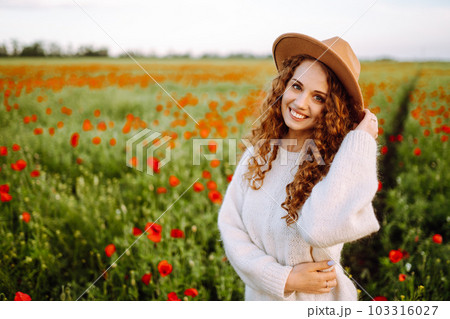 Young woman walking in amazing poppy field. Nature, vacation, relax and lifestyle. 103316027