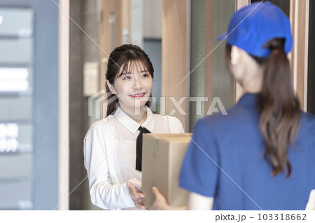 宅配便を受け取る若い女性 宅配便を受け取る若い女性 103318662
