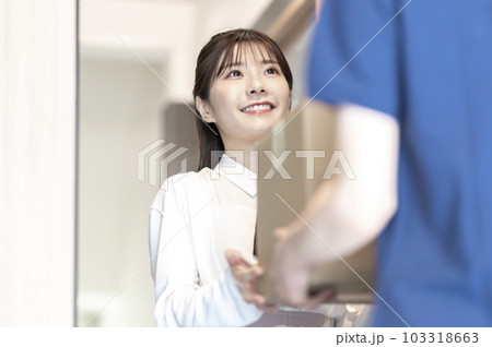 宅配便を受け取る若い女性 宅配便を受け取る若い女性 103318663