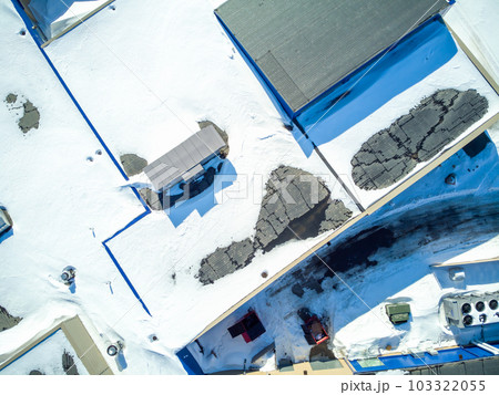 Elevated overhead drone view of a flat roofed building with snow load and ventilation units. Elevated overhead drone view of a flat roofed building with snow load and ventilation units. 103322055