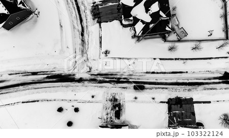 Aerial drone overhead view of a city street and plowed in residential driveway. Aerial drone overhead view of a city street and plowed in residential driveway. 103322124