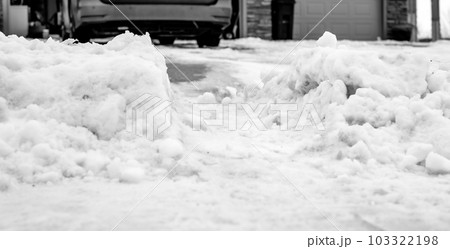 Snowbank at the end of a driveway left after city snowplows cleared a street. 103322198