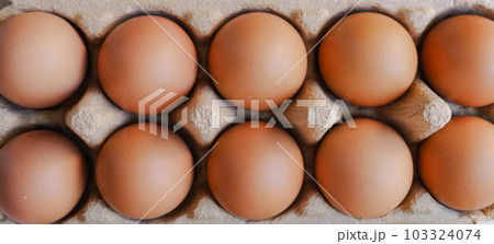 Close up group of organic eggs in brown carton box on wooden background. Close up group of organic eggs in brown carton box on wooden background. 103324074