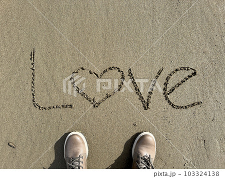 shoes on sandy beach with hand written love word 103324138