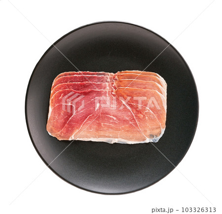 Slices of parma ham prosciutto in a black plate isolated on white background. 103326313
