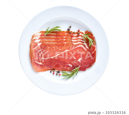 Spanish jamon cut, parma ham cutting with rosemary and spice in a plate isolated on white background. 103326316
