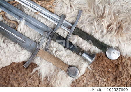Medieval swords on sheep fur 103327890