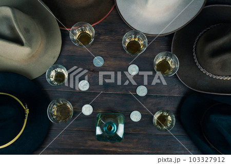 Bourbon shots with old west hats on table. Top view. Bourbon shots with old west hats on table. Top view. 103327912