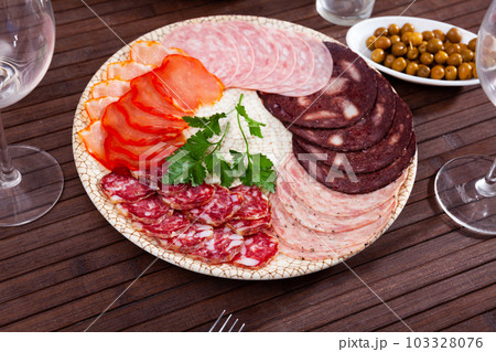 Slices of dry-cured loin, salami, morcilla with fresh parsley Slices of dry-cured loin, salami, morcilla with fresh parsley 103328076