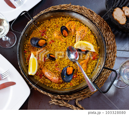 Spanish rice dish paella tinted with saffron. Prepared with olive oil and seafood 103328080