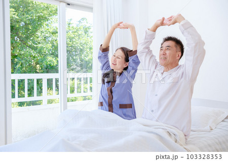寝室でストレッチをするシニア夫婦 寝室でストレッチをするシニア夫婦 103328353