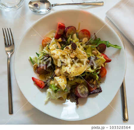 Salad with goat cheese, cherry tomatoes, arugula, nuts and raisins Salad with goat cheese, cherry tomatoes, arugula, nuts and raisins 103328564