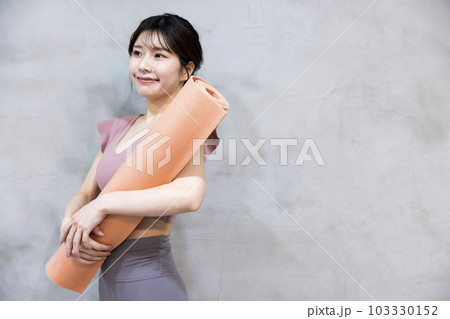 ヨガマットを持って立つ若い女性 ヨガイメージ ヨガマットを持って立つ若い女性 ヨガイメージ 103330152