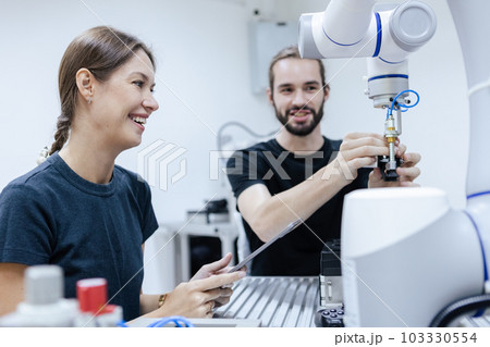 Male and female using tablet staff engineer with robot for education at class room. 103330554